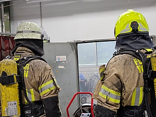 Rückansicht zweier voll ausgerüsteter Atemschutzgeräteträger